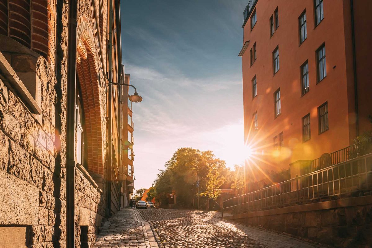 Stockholm, Sweden. Sunshine During Sunset Above Stockholm Street. Beautiful Street With Multi-storey House In Sunny Summer Evening. Cozy Side Street.